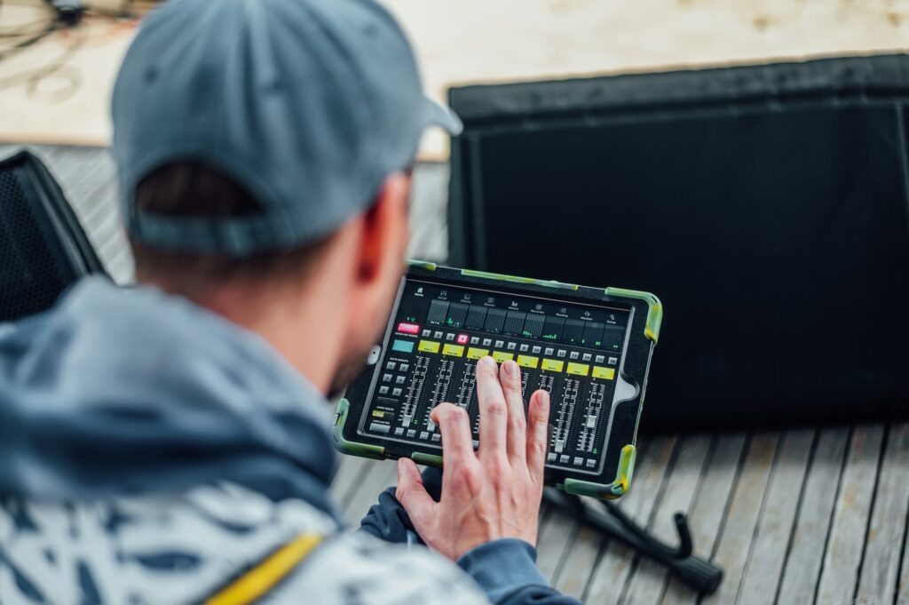 sound engineer adjusts the sound on a tablet with installed software for a digital mixing console